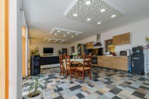 a kitchen and dining room with a table and chairs at Koma Vendégház in Aporliget