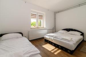 two beds in a white room with a window at Koma Vendégház in Aporliget +13 photos