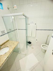 a bathroom with a shower and a sink and a toilet at Hotel Palmar in Guarujá