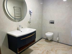 a bathroom with a sink and a mirror and a toilet at Hotel Ashad in Svalyava