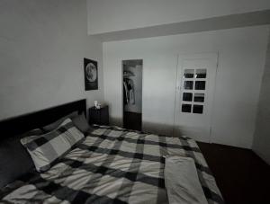 a bedroom with a bed with a checkered blanket at Cozy bedroom in terrace house in Sydney