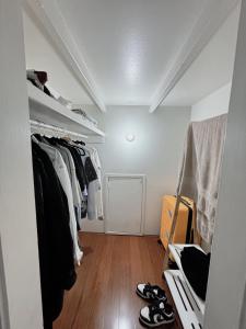 a walk in closet with shoes on a wooden floor at Cozy bedroom in terrace house in Sydney