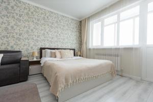 a bedroom with a large bed and a window at Sun Уш-Сункар in Almaty