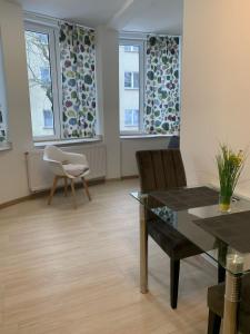 a living room with a table and chairs and windows at Apartamenty Św.Rocha in Białystok