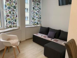 a living room with a couch and a chair at Apartamenty Św.Rocha in Białystok