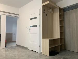 szafa z białymi drzwiami i drewnianymi półkami w obiekcie Apartamenty Św.Rocha w mieście Białystok