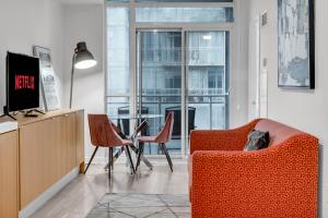 een woonkamer met een oranje bank en stoelen bij Spadina Modern suites in Toronto