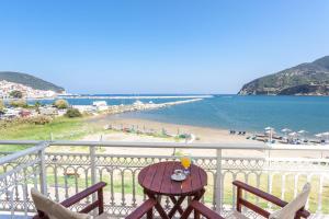 a table on a balcony with a view of the beach at MON REPOS in Panormos Skopelos +28 photos