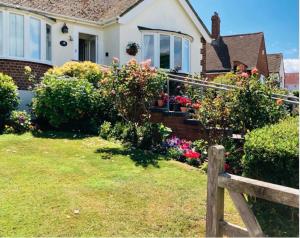 a house with flowers and a fence in the yard at Mariners Corner in Bexhill