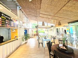 jadalnia ze stołami i krzesłami w restauracji w obiekcie Karcof Container Hostel w mieście Senggigi