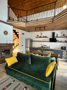 a living room with a green couch and a kitchen at Villa Pelahia in Slavske