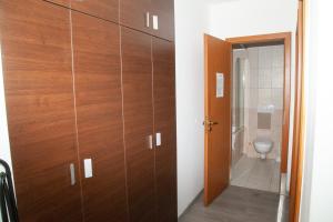 a bathroom with wooden cabinets and a toilet at Prater Residence Aparthotel in Budapest +35 photos