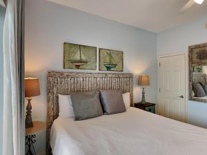 1 dormitorio con 1 cama blanca y 2 cuadros en la pared en Inn at Seacrest #206 en Rosemary Beach