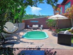 布希奧斯的住宿－Namorada Brava Guest House，一个带椅子和遮阳伞的小型游泳池