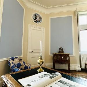 una habitación con una mesa y un reloj en la pared en Chateau Moncassin en Leyritz-Moncassin