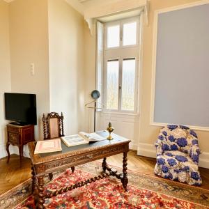 a living room with a table and a chair at Chateau Moncassin in Leyritz-Moncassin