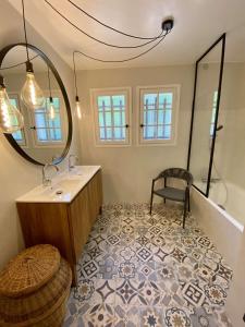 a bathroom with a sink and a mirror and a chair at Réf 143 Seignosse Estagnots, Villa" Assouinde" classée 4 étoiles avec Wifi pour 9 personnes au calme à proximité de la plage in Seignosse