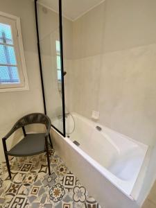 a white bath tub in a bathroom with a chair at Réf 143 Seignosse Estagnots, Villa" Assouinde" classée 4 étoiles avec Wifi pour 9 personnes au calme à proximité de la plage in Seignosse