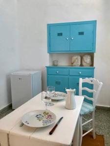 une table avec deux plaques et une armoire bleue dans l'établissement La maison du Pêcheur, à Kourélion