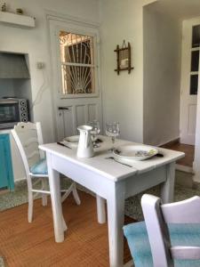 - une table et des chaises blanches avec des verres à vin dans l'établissement La maison du Pêcheur, à Kourélion