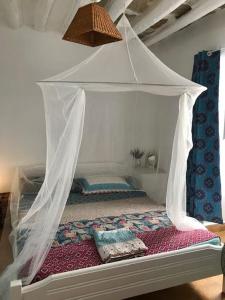 a bed with a canopy in a bedroom at La maison du Pêcheur in Kourélion