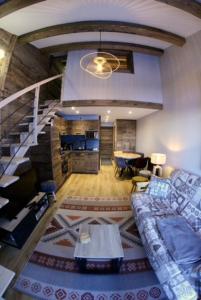 un soggiorno con divano e una scala di Appartement La Plagne 1800 a La Plagne Tarentaise