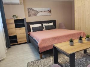 ein kleines Schlafzimmer mit einem Bett und einem Tisch in der Unterkunft Апартаменты в центре Ужгорода СКАЛА in Uschhorod