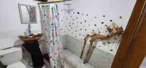 y baño con cortina de ducha y aseo. en Sweet Home en Cabuya