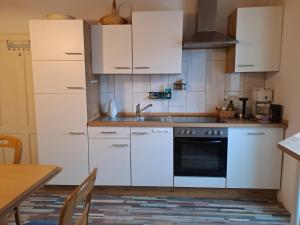 a kitchen with white cabinets and a sink at TheGarden Bed&Bike in Gmunden