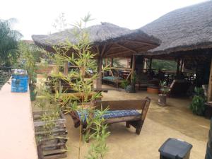 a patio with a bench and a large umbrella at Tourist Home in Mbale