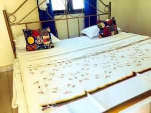 a bed with a metal frame with flowers on it at Tourist Home in Mbale