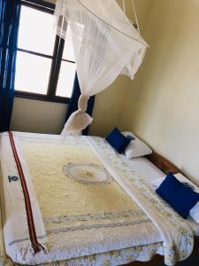 a bedroom with a bed with a canopy and a window at Tourist Home in Mbale