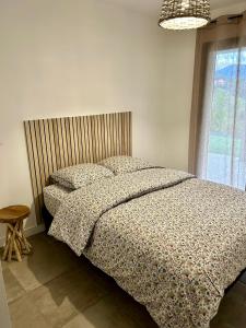 una camera da letto con letto, cuscini e finestra di Bas de villa avec jardin idéalement situé entre Ajaccio et Porticcio a Bastelicaccia