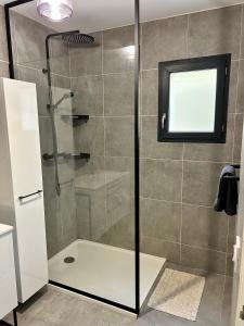 a bathroom with a shower with a glass door at Bas de villa avec jardin idéalement situé entre Ajaccio et Porticcio in Bastelicaccia