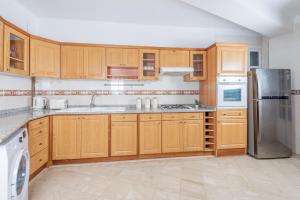 a kitchen with wooden cabinets and stainless steel appliances at Appartement Luxueux à Hydra in Hydra