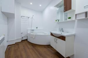 un bagno bianco con vasca e lavandino di Appartement Luxueux à Hydra a Hydra
