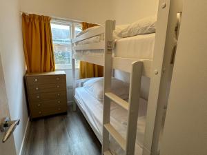a room with two bunk beds and a window at Carmen Sylva Llandudno Beach ground floor Flat in Llandudno