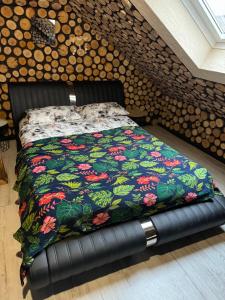 ein Bett mit einer bunten Decke auf einem Zimmer in der Unterkunft APARTAMENT NEON JACUZZI W RYNKU KIELCE z Parkingiem-Możliwosć wyżywienia in Kielce