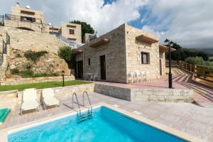 a villa with a swimming pool and a house at Fotini Traditional Villas in Kavoúsion