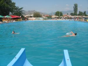 two people swimming in a large swimming pool at Hotel Markovi Kuli TD in Prilep