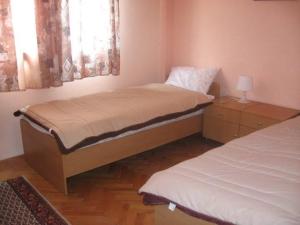 a bedroom with two beds and a lamp on a table at Hotel Markovi Kuli TD in Prilep