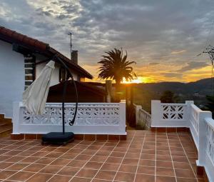 an umbrella on the roof of a house with the sunset at BILBO Near ático rural con terraza in Basauri