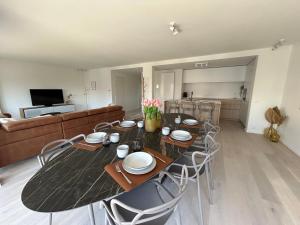 a dining room with a table and chairs and a couch at ASTRID 0301 - App voor 6 personen in De Panne