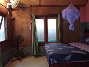 a bedroom with a bed and a window at Pelangi Homestay Bungalow Gili gede in Sekotong