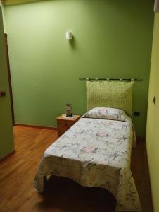 - une chambre verte avec un lit et du parquet dans l'établissement A casa di Annarella, à Urbino
