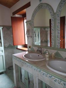 La salle de bains est pourvue de 2 lavabos et d'un grand miroir. dans l'établissement A casa di Annarella, à Urbino