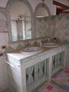 La salle de bains est pourvue de 2 lavabos et d'un miroir. dans l'établissement A casa di Annarella, à Urbino