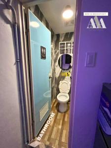 un piccolo bagno con servizi igienici e porta viola di AAA Bed & Breakfast a General Trias