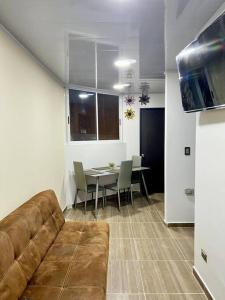 een woonkamer met een bank en een tafel met stoelen bij Aparta estudio en Acacias - Meta in Acacías
