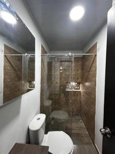 een badkamer met een toilet en een glazen douche bij Aparta estudio en Acacias - Meta in Acacías